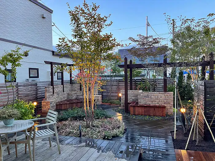 シックな色合いで雑木やパーゴラのあるリゾートチックな庭