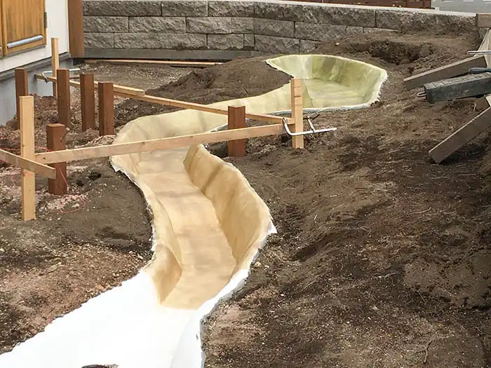 流れの土台(コンクリート)にFRP防水層を施工している様子