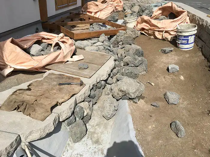 流れの防水層に壮瞥石を川辺の様にb組んでいる様子