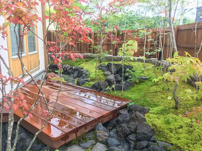 流れの中に縁台が迫り出す自然風苔庭